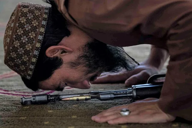 A Taliban fighter prays at a mosque during Friday prayers in Kabul, Afghanistan, Friday, September 17, 2021. (Photo by Bernat Armangue/AP Photo)