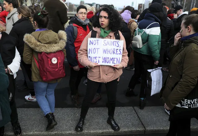 A woman stands with a placard during a woman's protest event for International Women's Day, in Dublin city centre, Ireland, Friday March 8, 2019. (Photo by Brian Lawless/PA Wire via AP Photo)