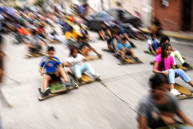 Children compete in the traditional street wooden go kart race known as “carruchas”, as part of the Epiphany celebrations in Caracas, Venezuela, Saturday, January 6, 2024. (Photo by Matias Delacroix/AP Photo)