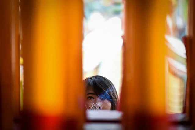 A woman prays in a Chinese temple during Lunar New Year celebrations in Bangkok on February 5, 2019. (Photo by Lillian Suwanrumpha/AFP Photo)