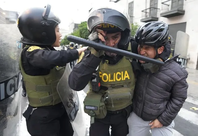 Police detain a protester in support of ousted President Pedro Castillo, during clashes with police in Lima, Peru, Thursday, December 8, 2022. Peru's Congress voted to remove Castillo from office Wednesday and replace him with the vice president, shortly after Castillo tried to dissolve the legislature ahead of a scheduled vote to remove him. (Photo by Fernando Vergara/AP Photo)