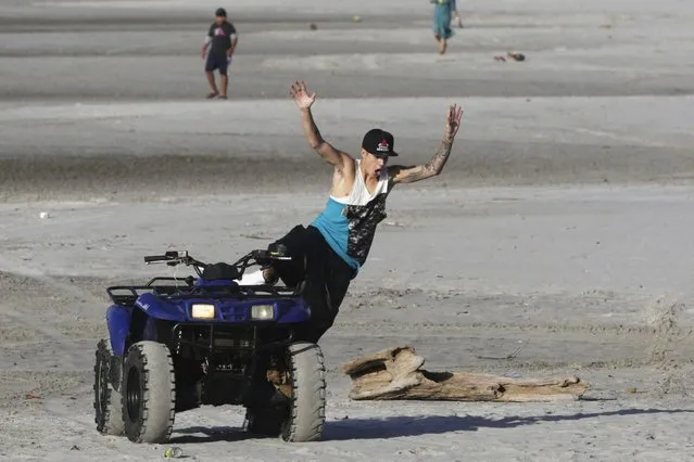 Canadian singer Justin Bieber jumps from a quad bike at a resort in Punta Chame, on the outskirts of Panama City January 27, 2014. Teen pop star Justin Bieber remains in Panama just three days after his turbulent off-stage life landed him in a Florida jail. Bieber was arrested on January 23rd for drunk driving after he was allegedly drag racing on a Miami Beach street. (Photo by Carlos Jasso/Reuters)