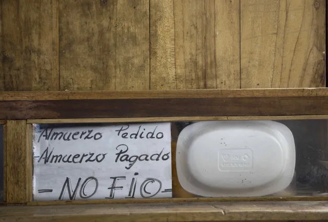 In this April 14, 2015 photo, a handwritten sign that reads in Spanish “Ordered lunch. Paid lunch. I don't trust” is posted inside a prison cell at the now empty Garcia Moreno Prison, during a guided tour for the public in Quito, Ecuador. The prisoner who used this cell sold food and ran a small general store inside, selling items to his fellow inmates. (Photo by Dolores Ochoa/AP Photo)