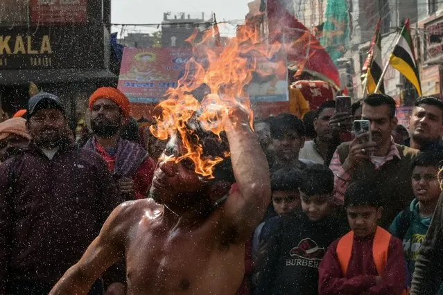 A dancer performs a fire breathing act during a procession to mark the 669th anniversary of the birth of Hindu Guru Bawa Lal Dayal in Amritsar on February 9, 2024. (Photo by Narinder Nanu/AFP Photo)