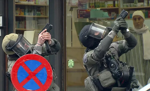 Armed Belgian police secure the area, in this still image taken from video, upon their arrival in Molenbeek, near Brussels, Belgium, March 18, 2016. Belgian-born Salah Abdeslam, one of the main suspects from November's Paris attacks was arrested after a shootout with police in Brussels on Friday, the Belgian federal prosecutor's office said. (Photo by Reuters/VTM via Reuters TV)