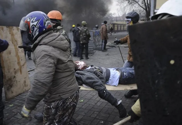Anti-government protesters carry an injured man on a stretcher after clashes with riot police in Independence Square in Kiev February 20, 2014. (Photo by Maks Levin/Reuters)
