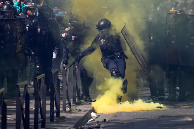 A police officer kicks a canister at a demonstration during Act XXIII (the 23rd consecutive national protest on Saturday) of the yellow vests movement in Paris, France, April 20, 2019. (Photo by Yves Herman/Reuters)
