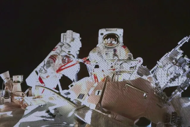 In this image released by the Xinhua News Agency, a photo taken on a screen shows Chinese astronaut Wang Yaping steps out from the space station's Tianhe core module, at Beijing Aerospace Control Center on Sunday, November 7, 2021. Wang Yaping has become the first Chinese woman to conduct a spacewalk as part of a six-month mission to the country's space station. Wang and fellow astronaut Zhai Zhigang left the station's Tianhe core module on Sunday evening Beijing time, spending more than six hours installing equipment and carrying out tests alongside the station's robotic service arm. (Photo by Guo Zhongzheng/Xinhua via AP Photo)