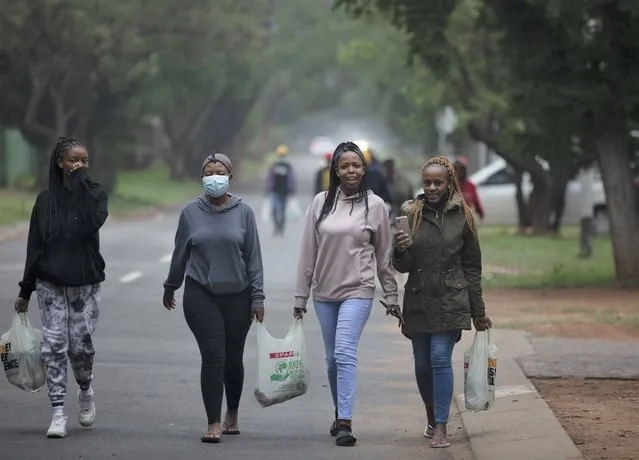 Students from the Tshwane University of Technology make their way back to their residence in Pretoria, South Africa, Saturday, November 27, 2021. As the world grapples with the emergence of the new variant of COVID-19, scientists in South Africa – where omicron was first identified – are scrambling to combat its spread across the country. (Photo by Denis Farrell/AP Photo)