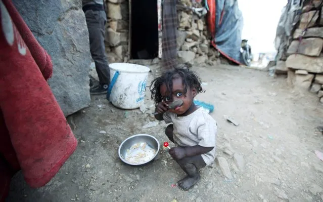 A displaced child, who fled from fighting in Taiz, eats rice in a slum on the outskirts of Sanaa, Yemen May 7, 2019. Picture taken May 7, 2019. (Photo by Khaled Abdullah/Reuters)