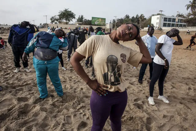 In this photo taken on Tuesday, May 7, 2015, Dioumayatou Ba, center, stretches during a class on Fann Beach in Dakar, Senegal. (Photo by Jane Hahn/AP Photo)