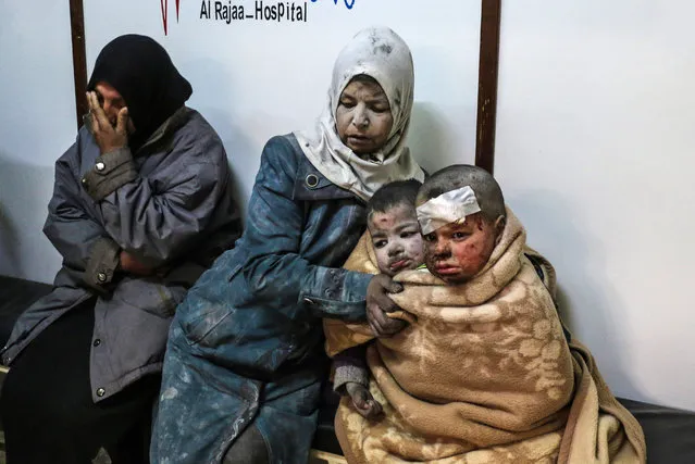 A Syrian woman sits with injured children at a hospital following a reported strike by government forces in the rebel-held distric of Barzah, on the north-eastern outskirts of the capital Damascus, on February 20, 2017. (Photo by Saria Abu Zaid/AFP Photo)