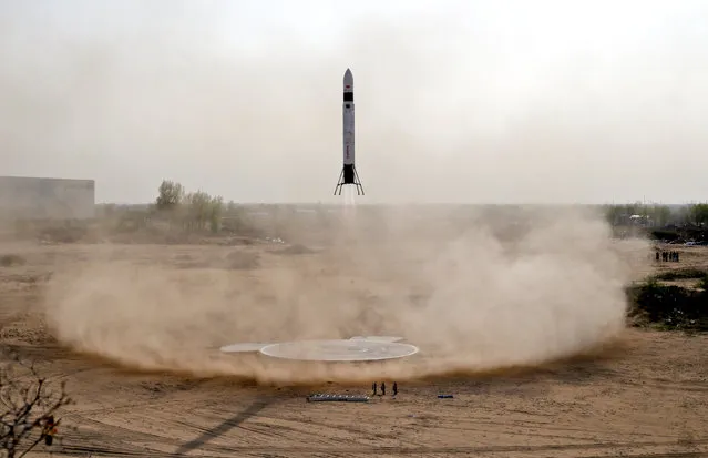 LinkSpace's reusable rocket RLV-T5, also known as NewLine Baby, returns to the landing site during a test launch on a vacant plot of land near the company's development site in Longkou, Shandong province, China, April 19, 2019. During initial tests of their 8.1-metre tall reusable rocket, Chinese engineers from LinkSpace, a start-up led by China's youngest space entrepreneur, used a Kevlar tether to ensure its safe return. Just in case. But when the Beijing-based company's prototype, called NewLine Baby, successfully took off and landed last week for the second time in two months, no tether was needed. The 1.5-tonne rocket hovered 40 metres above the ground before descending back to its concrete launch pad after 30 seconds, to the relief of 26-year-old chief executive Hu Zhenyu and his engineers - one of whom cartwheeled his way to the launch pad in delight. LinkSpace, one of China's 15-plus private rocket manufacturers, sees these short hops as the first steps towards a new business model: sending tiny, inexpensive satellites into orbit at affordable prices. Demand for these so-called nanosatellites – which weigh less than 10 kilogrammes and are in some cases as small as a shoebox – is expected to explode in the next few years. And China's rocket entrepreneurs reckon there is no better place to develop inexpensive launch vehicles than their home country. (Photo by Jason Lee/Reuters)