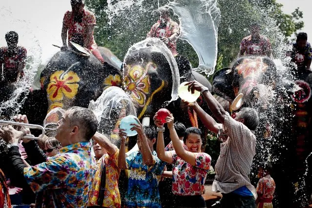 People are sprayed with water thrown by elephants in a preview of the upcoming Songkran Festival celebration, the Thai traditional New Year, also known as the water festival in the ancient world heritage city of Ayutthaya, Thailand, 11 April 2016. (Photo by Diego Azubel/EPA)