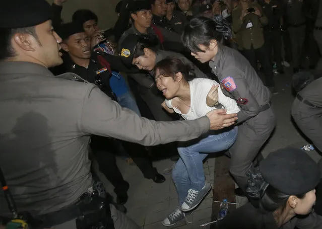 Police officers drag a student protester in Bangkok, Thailand Friday, May 22, 2015. Thai police detained anti-coup protestors who attempted to organize activity marking the first anniversary of the military coup. (Photo by Sakchai Lalit/AP Photo)