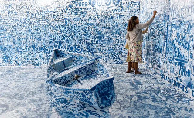 People visit the interactive installation “Add Color (Refugee Boat)” by artist Yoko Ono, made up of an empty room with a boat where visitors can paint messages and images on walls, in New York, New York, USA, 27 June 2019. The exhibit is part of the Lower Manhattan Cultural Council's annual River to River Festival which runs until 29 June 2019. (Photo by Justin Lane/EPA/EFE)