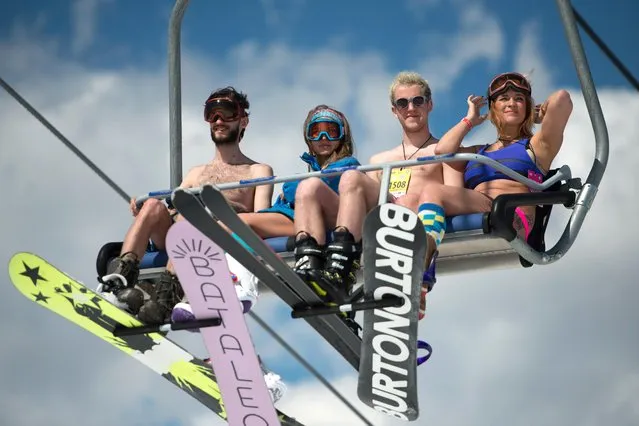 People dressed in swimsuits seen in a chairlift during the BoogelWoogel alpine carnival at the Rosa Khutor Alpine Resort in Krasnaya Polyana, Sochi, Russia on April 1, 2017. (Photo by Artur Lebedev/TASS)