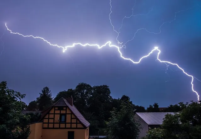 A strong lightning lights up the night sky  during a thunderstorm above a residential area in Sieversdorf Brandenburg, Germany, 07 July 2015. After the hot summer days heavy thunderstorms are often experienced over Brandenburg at night. (Photo by Patrick Pleul/EPA)