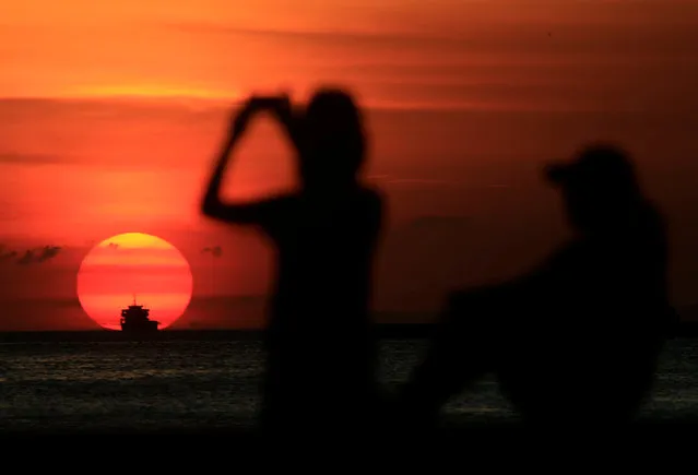 A group of friends are silhouetted as they take a photograph while watching the sun set along the coast of Manila bay in Metro Manila, Philippines January 27, 2017. (Photo by Romeo Ranoco/Reuters)