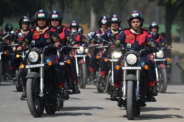 Indian Border Security Force (BSF) personnel from women's motorcycle team “Sema Bhawani” ride their Royal Enfield motorcycles during the BSF Seema Bhawani Shaurya expedition-Empowerment Ride at India Gate in New Delhi in March 8, 2022, on the occasion of International Women's Day. (Photo by Money Sharma/AFP Photo)