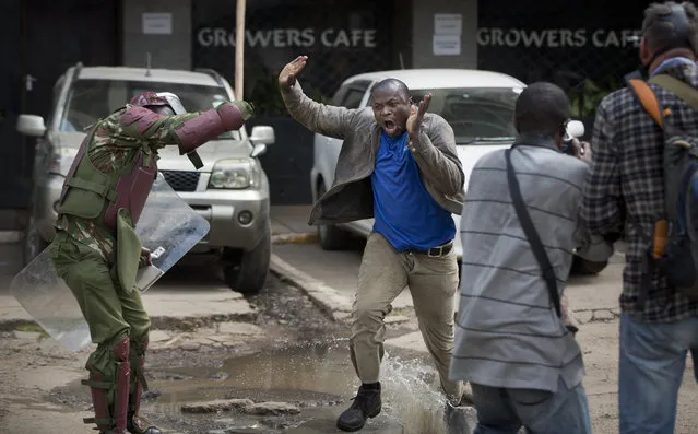 An opposition supporter yells out as he is beaten with a wooden club by riot police while trying to flee, during a protest in downtown Nairobi, Kenya Monday, May 16, 2016. (Photo by Ben Curtis/AP Photo)