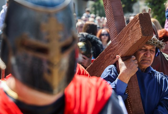 Melios Tourvas, community leader of the village, carries a cross in a re-enactment of the crucifixion of Jesus Christ, on Good Friday, during Orthodox Easter celebrations in Kathikas village, Cyprus on April 14, 2023. (Photo by Yiannis Kourtoglou/Reuters)