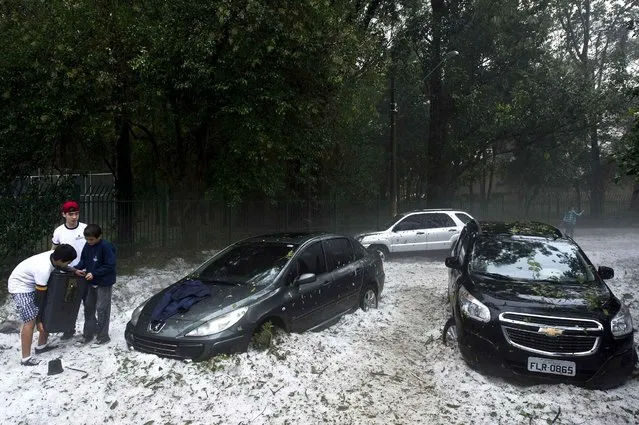 Vehicles are trapped in the hail in a street after a hailstorm in the Aclimacao neighborhood in Sao Paulo, Brazil on May 19, 2014. After the severe overnight hailstorm a layer of hailstones as deep as 20 centimeters covered streets and parks, drawing people to make snowmen and play in the ice, an unusual scene to the city. (Photo by Nelson Almeida/AFP Photo)
