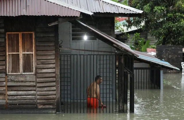 A resident is seen inside his partly submerged house during a flash flood, following a heavy rain fall in Kuala Lumpur, Malaysia, March 7, 2022. (Photo by Hasnoor Hussain/Reuters)
