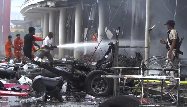 In this image made from video, firefighters try to extinguish the fire after a bomb hidden in a car exploded outside a large shopping center in Pattani province, southern Thailand, Tuesday, May 9, 2017. Suspected insurgents detonated a car bomb Tuesday outside the busy shopping center wounding more than 50 people in a huge blast that ripped the building apart and sent people running for their lives. (Photo by AP Photo)