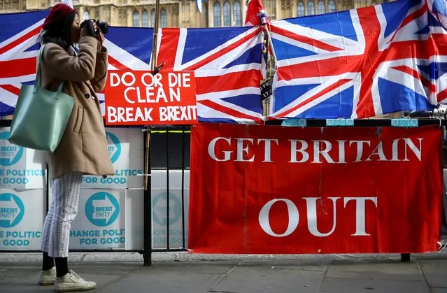 A woman takes pictures next to pro-Brexit placards outside the Houses of Parliament in London, Britain, October 28, 2019. (Photo by Hannah McKay/Reuters)