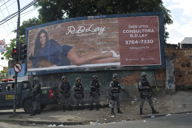 National security forces patrol the Chapadao complex slum in Rio de Janeiro, Brazil, Monday, May 15, 2017. Hundreds of officers arrived to reinforce security in the city where heavily armed gangs run drug businesses from the slums and have shoot outs with rival gangs over territory. (Photo by Silvia Izquierdo/AP Photo)