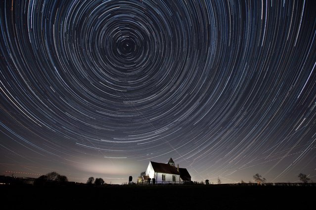 This photograph of the freezing night sky “swirling around the North Star” over St Hubert’s Church in Idsworth, Hampshire, UK was created over two and a half hours using 250 images in the first decade of January 2024. (Photo by Chris Gorman/Big Ladder)