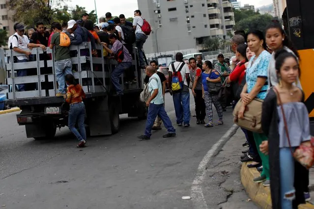 People board a truck outside a closed metro station during a blackout in Caracas, Venezuela on July 22, 2019. (Photo by Carlos Garcia Rawlins/Reuters)