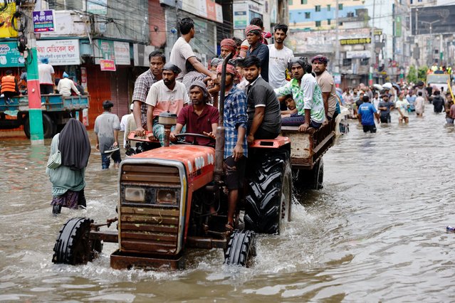 People move on a tractor through a flooded street amid severe flooding in Feni, Bangladesh, on August 25, 2024. (Photo by Mohammad Ponir Hossain/Reuters)