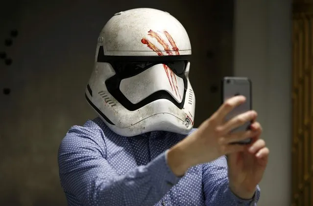 A journalist takes a selfie whilst wearing a replica of Finn's Stormtrooper helmet from “Star Wars: The Force Awakens”, in the Propshop headquarters at Pinewood Studios near London, Britain May 25, 2016. (Photo by Peter Nicholls/Reuters)