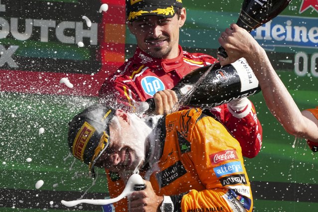 McLaren driver Lando Norris of Britain is sprayed with champagne as he celebrates after winning the Formula One Dutch Grand Prix race at the Zandvoort racetrack, Netherlands, Sunday, August 25, 2024. (Photo by Peter Dejong/AP Photo)