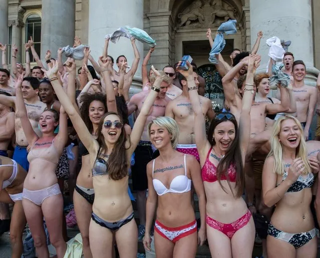 A flashing flashmob paraded around central London in their underwear in a protest over bank charges, on June 13, 2014. The semi-naked gang stripped down to their bras and briefs – giving morning commuters an eyeful. The scantily clad protesters stunned passengers at Liverpool Street Station and were also spotted in Angel, Farringdon and Kings Cross Square. More than 100 daring campaigners turned out for the event – which luckily coincided with the warmest day of the year so far. (Photo by Jeff Moore)