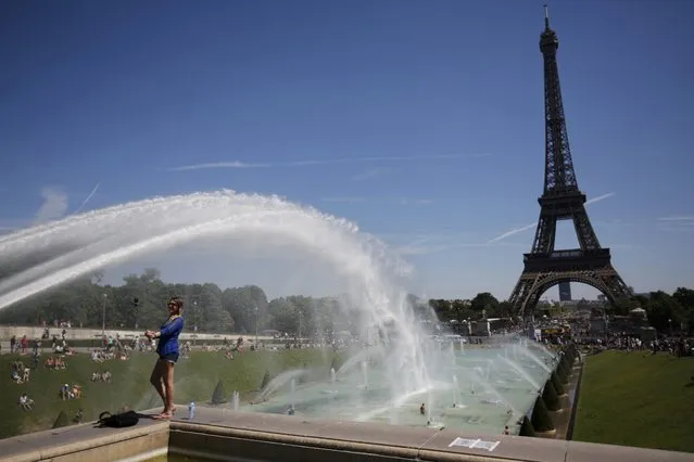 A tourist makes a selfie in front of the Eiffel Tower in Paris, France, August 2, 2015 as warm summer temperatures return to the French capital. (Photo by Stephane Mahe/Reuters)