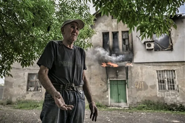 An eldery man reacts in front of the apartment building where he lives, as it is burning after a shelling in the city of Lysychansk, in the eastern Ukrainian region of Donbas, on June 5, 2022. (Photo by Aris Messinis/AFP Photo)