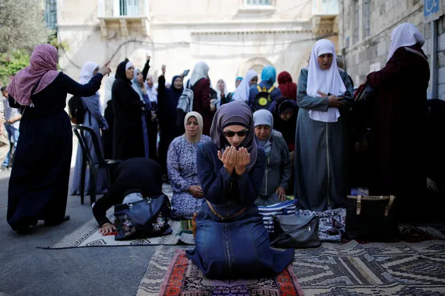 Palestinian women pray as others shout slogans outside the compound known to Muslims as Noble Sanctuary and to Jews as Temple Mount, in Jerusalem's Old City July 27, 2017. (Photo by Amir Cohen/Reuters)