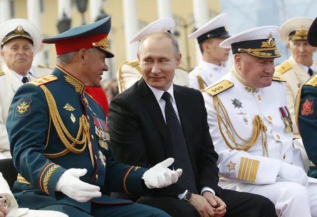 Russian President Vladimir Putin, center, smiles chatting with Defence Minister Sergei Shoigu as they attend the military parade during the Navy Day celebration in St.Petersburg, Russia, on Sunday, July 30, 2017. (Photo by Alexander Zemlianichenko/AP Photo/Pool)