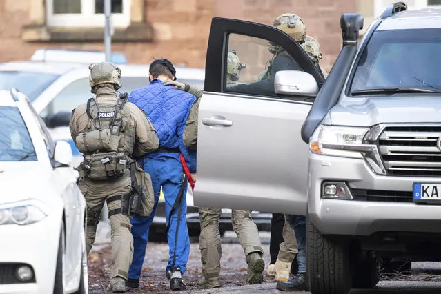 Police officers escort a s suspect after his arrival at the federal prosecutor's office in Karlsruhe Germany, Tuesday, February 11, 2020. Almost half a year after the murder of a Georgian in Berlin, the Federal Prosecutor General wants to obtain his own arrest warrant against the suspect. (Photo by Sebastian Gollnow/dpa via AP Photo)