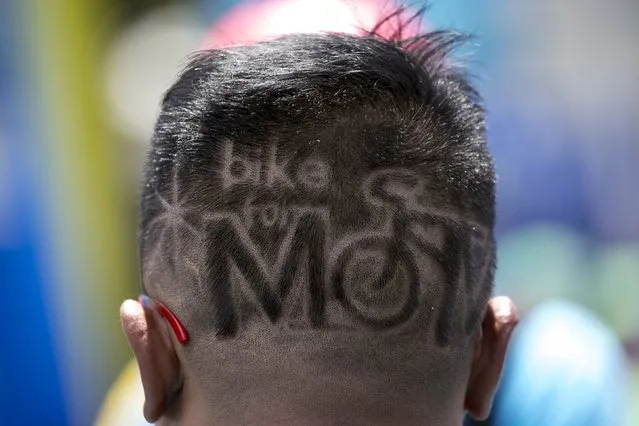 A participant with the name of the event shaved into his hair takes part in the “Bike for Mom” event in Bangkok, Thailand, August 16, 2015. Thai Crown Prince Maha Vajiralongkorn led 40,000 cyclists on a 43-km (27-mile) course in Bangkok on Sunday, to celebrate the 83rd birthday of Thailand's Queen Sirikit, which fell on August 12. (Photo by Athit Perawongmetha/Reuters)