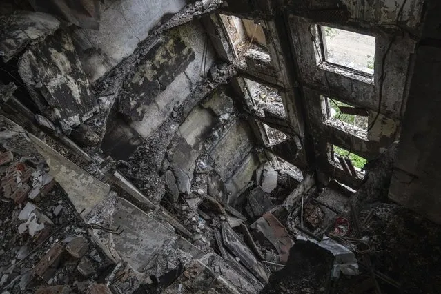 An apartment house destroyed after a Russian attack in Saltivka district in Kharkiv, Ukraine, Tuesday, July 5, 2022. (Photo by Evgeniy Maloletka/AP Photo)