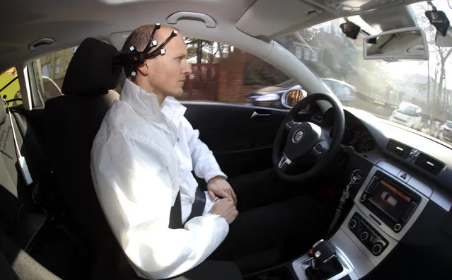 Daniel Goehring of the AutoNOMOS research team of the Artificial Intelligence Group at the Freie Universitaet (Free University) demonstrates a hands-free driving of the research car named “MadeInGermany” during a test in Berlin, 2011. The car, a modified Volkswagen Passat, is controlled by “BrainDriver” software with a neuroheadset device which interprets electroencephalography signals with additional support from latest radar sensing technology and cameras. (Photo by Fabrizio Bensch/Reuters)