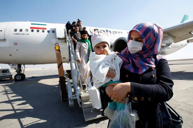 Passengers wearing protective masks disembark from a plane upon their arrival at Najaf airport, amid the new coronavirus outbreak, Iraq on February 21, 2020. (Photo by Alaa al-Marjani/Reuters)