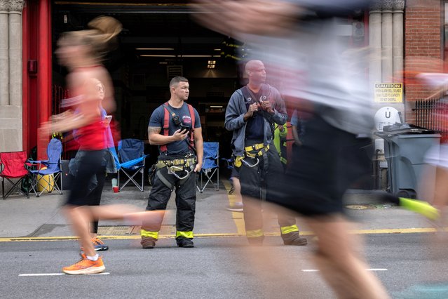 Firefighters from the New York Fire Department watch as runners make their way through the Brooklyn borough in New York on November 3, 2024. (Photo by Maye-E Wong/Reuters)