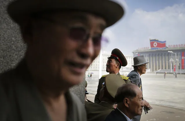North Korean men wait for the start of a parade to celebrate the anniversary of the Korean War armistice agreement, Sunday, July 27, 2014, in Pyongyang, North Korea. North Koreans gathered at Kim Il Sung Square as part of celebrations for the 61st anniversary of the armistice that ended the Korean War. (Photo by Wong Maye-E/AP Photo)