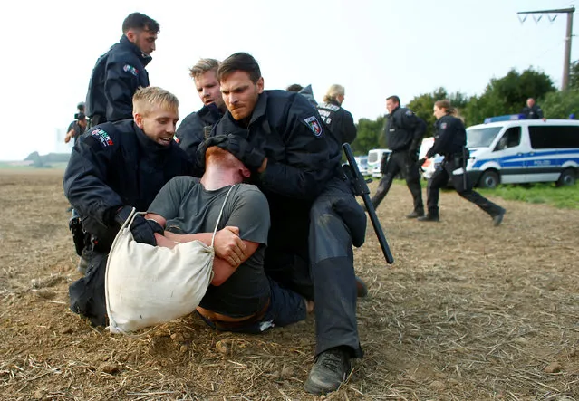 German police remove a protester during “Ende Gelaende” demonstrations against open cast brown coal mining near Bedburg Rath, Germany, August 26, 2017. (Photo by Thilo Schmuelgen/Reuters)