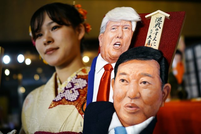 An employee of Kyugetsu, a Japanese traditional doll company, poses with special “hagoita” battledores featuring President-elect Donald Trump and Japanese Prime Minister Shigeru Ishiba Tuesday, December 3, 2024, in Tokyo. (Photo by Eugene Hoshiko/AP Photo)
